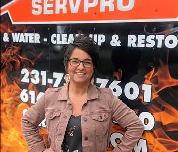 Female Marketing Manager standing in front of fire/water large loss trailer