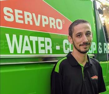 Male employee Steven next to green SERVPRO van