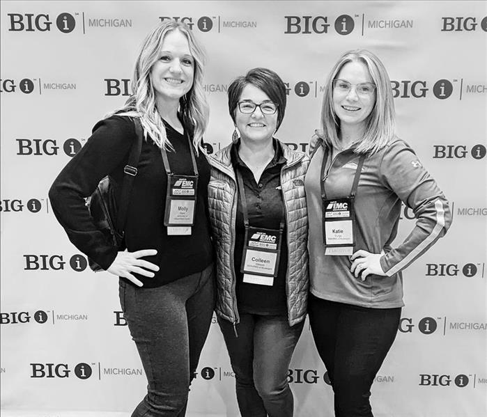 Marketing gals standing in front of Big I Michigan backdrop