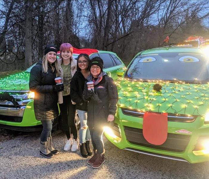 Marketing Gals standing in front of decorated SERVPRO cars