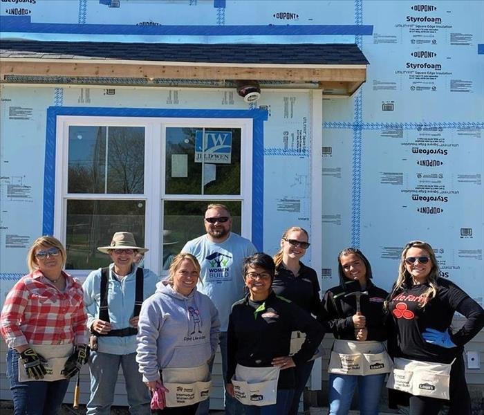 Group of people standing in front of Habitat for Humanity house