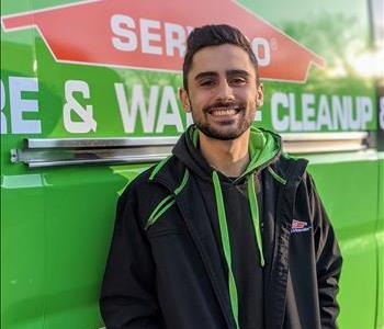 Male employee Anthony next to green SERVPRO van